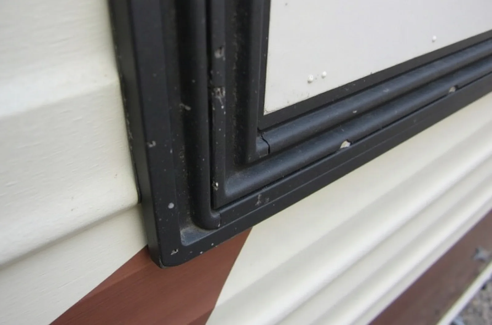 Worn black rubber wiper seal on an RV slide-out edge, a common cause of increased RV slide out repair cost.